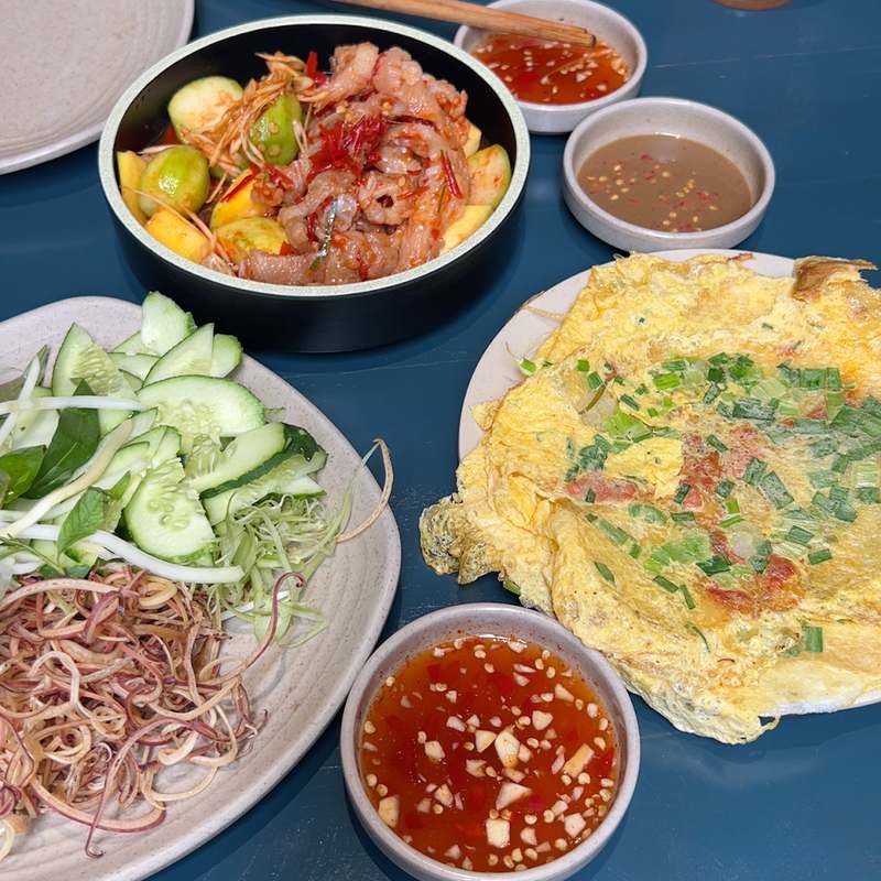 Bánh ép ăn kèm gỏi, rau sống và chén nước chấm